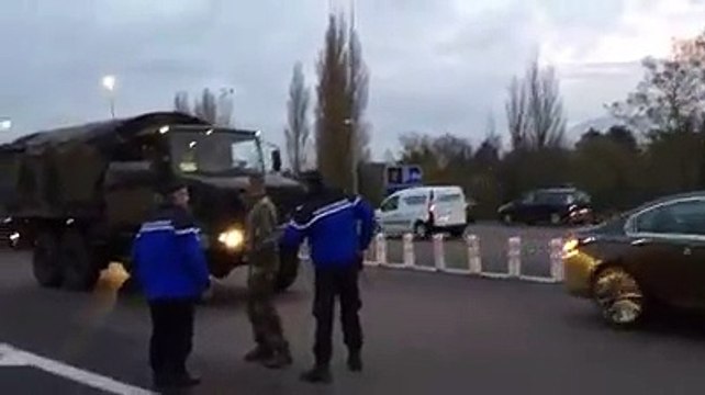 Des gendarmes arrêtent des militaires qui ont un gilet jaune sur leur tableau de bord.
