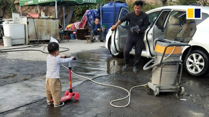 Toddler queues patiently for car wash ... for his scooter