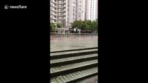 Resident walks on flooded pavement in Hong Kong in aftermath of Typhoon Mangkhut