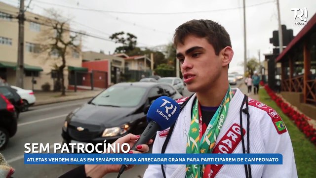 Atletas vendem balas em semáforo para arrecadar dinheiro