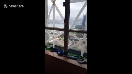 Calm after the storm: People remove duct tape from windows following Typhoon Mangkhut