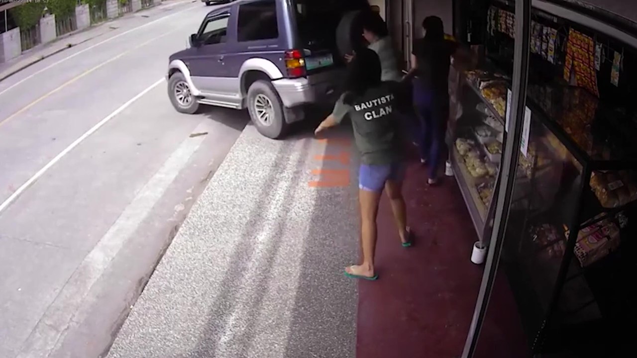 Une voiture recule toute seule dans la devanture d'un magasin