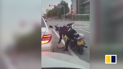 A passerby throws trash back into a litterbug’s car