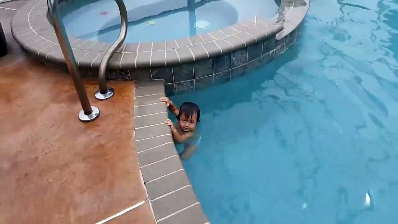 A baby is having fun swimming in a pool by himself!