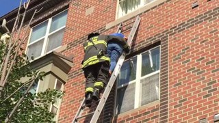 Firefighters Helps Elderly Woman Down a Ladder as Fire Rages