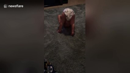 Diapered baby attempts his first somersaults all by himself