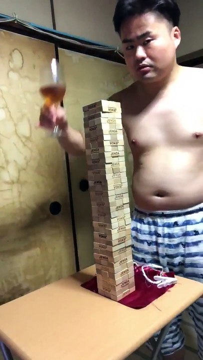 Le coup de la nappe sur une table avec une tour de Jenga et un verre à vin