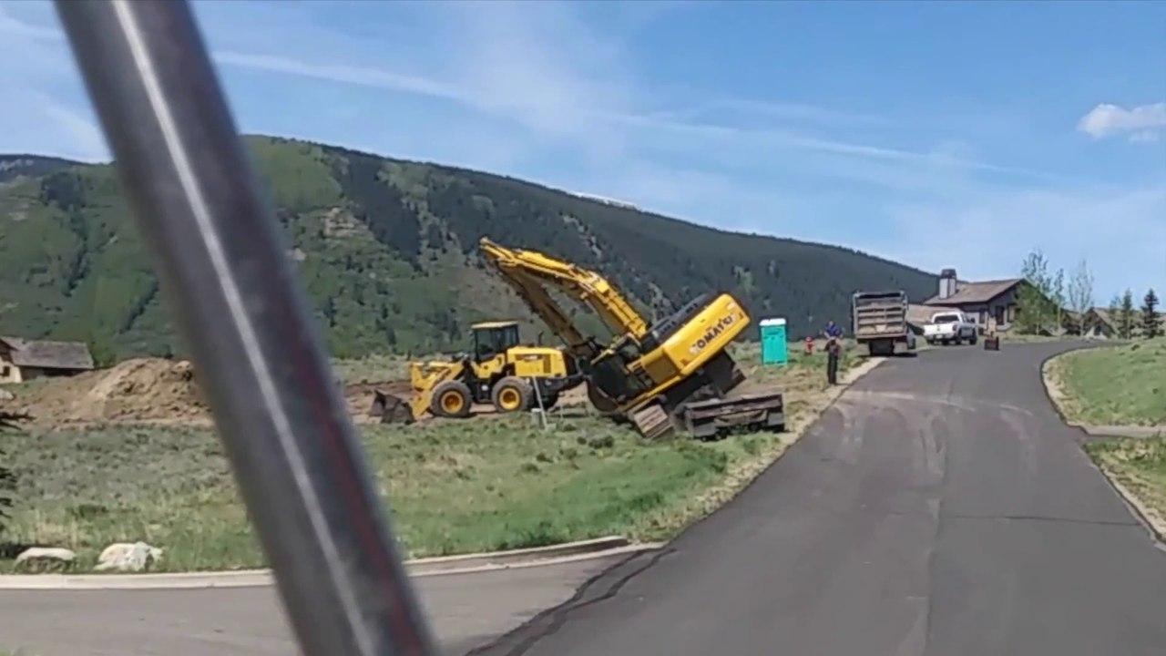 L'ouvrier qui conduit la pelleteuse a un petit problème