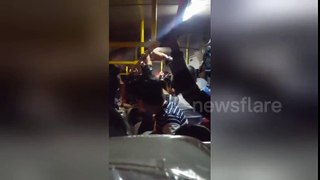 Bus driver dangling from roof to collect fares