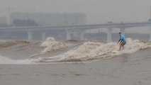 Des surfeurs tentent de dompter la vague géante du fleuve Qiantang en Chine