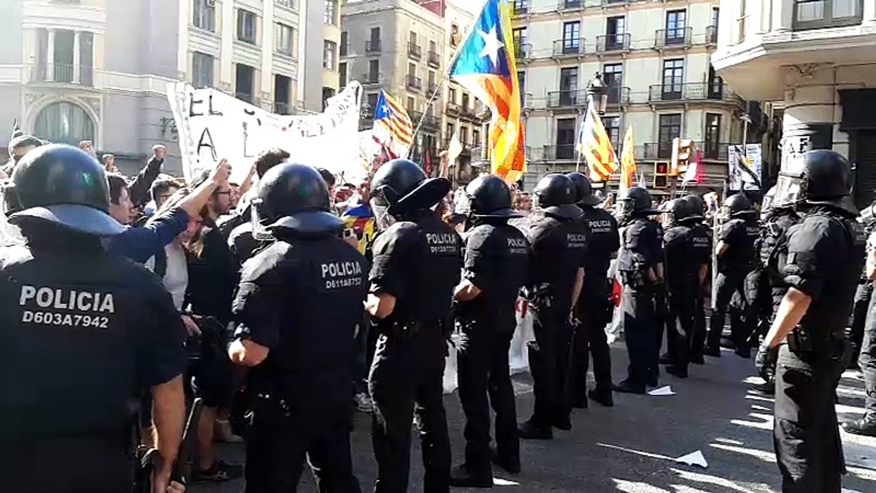 Els manifestants canten els Segadors davant del cordó de Mossos d'Esquadra