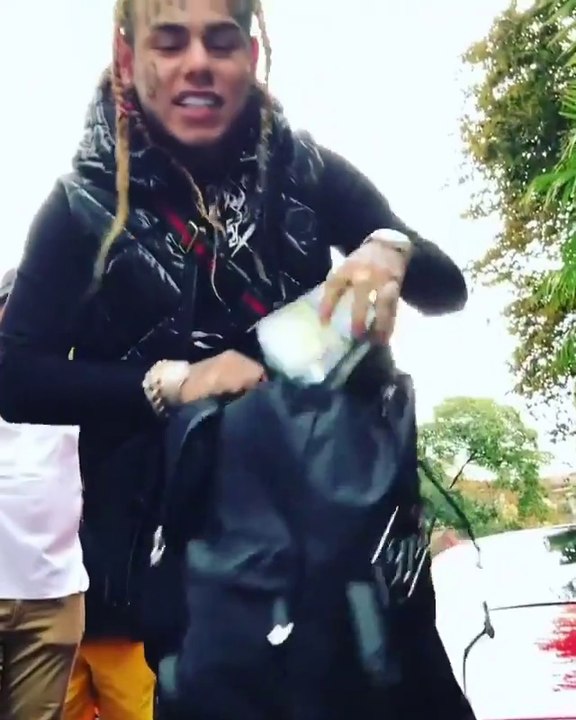 Le rappeur 6ix9ine jette tout son argent au sol.