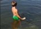 Little Boy Plays With New Fish Friends in Lake