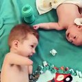 Infant giving feeder to other infant