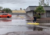 Man Surfs Along Flooded Street in Casa Grande, Arizona