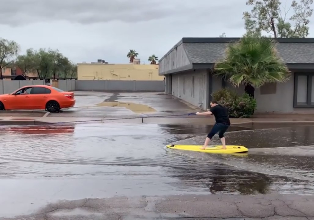 Man Surfs Along Flooded Street in Casa Grande, Arizona