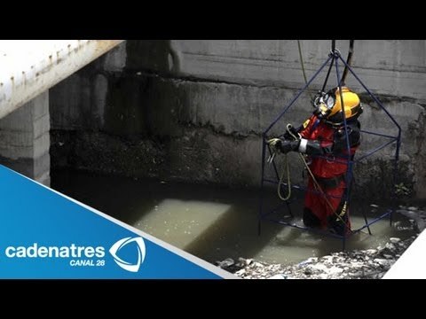Buzo se sumerge en aguas negras para mantener libre de objetos el drenaje de México