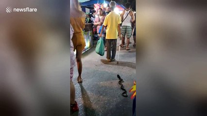 Old man has fun scaring people with his toy snake