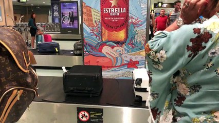 Hungover lad laying on the baggage collection conveyor belt at the airport