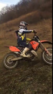 Man ghost riding a KTM drops his motorbike halfway up hill. Motorbike knocks his friend down hill