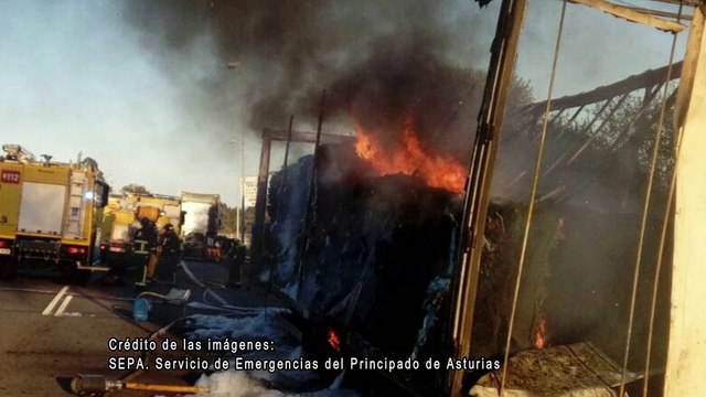 Bomberos intervienen para apagar el fuego en el remolque de un camión cargado de bobinas de papel en la A-8 en Colunga, Asturias