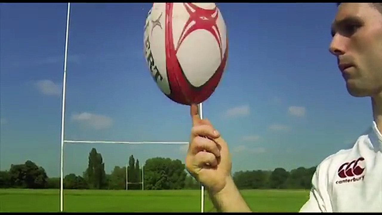guy balances and does tricks with rugby ball