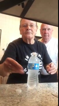 Une grande mère fait une blague à son mari avec une bouteille d'eau