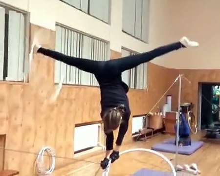 Girl Hula Hoops While Standing Upside Down on Thin Rope - 989678