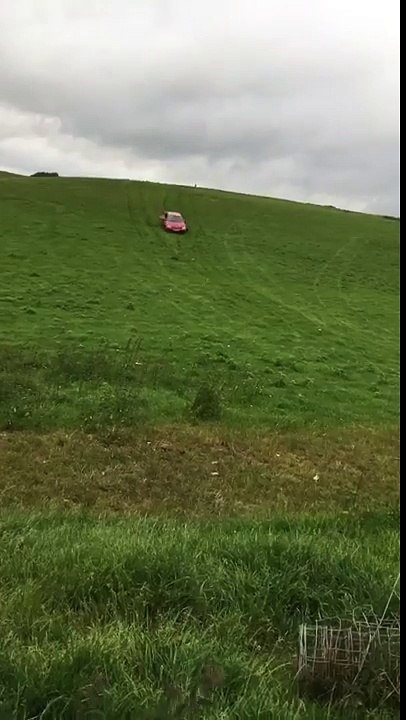 drives an old banger down a hill and jumps it over a bump