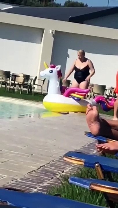 Girl trying to get in the pool on an inflatable gets a push from a mate