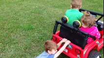 Le petit garçon s'accroche pendant que de minuscules amis roulent à toute allure sur les roues motrices