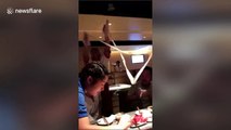 Waiter pulls single-strand noodle onto waitress’s hair