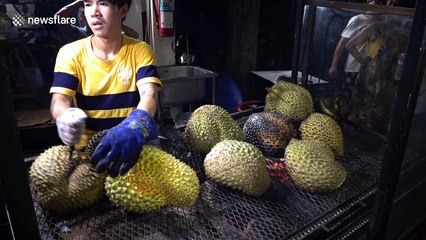 These tourists are eating durian flame-grilled with a blow torch