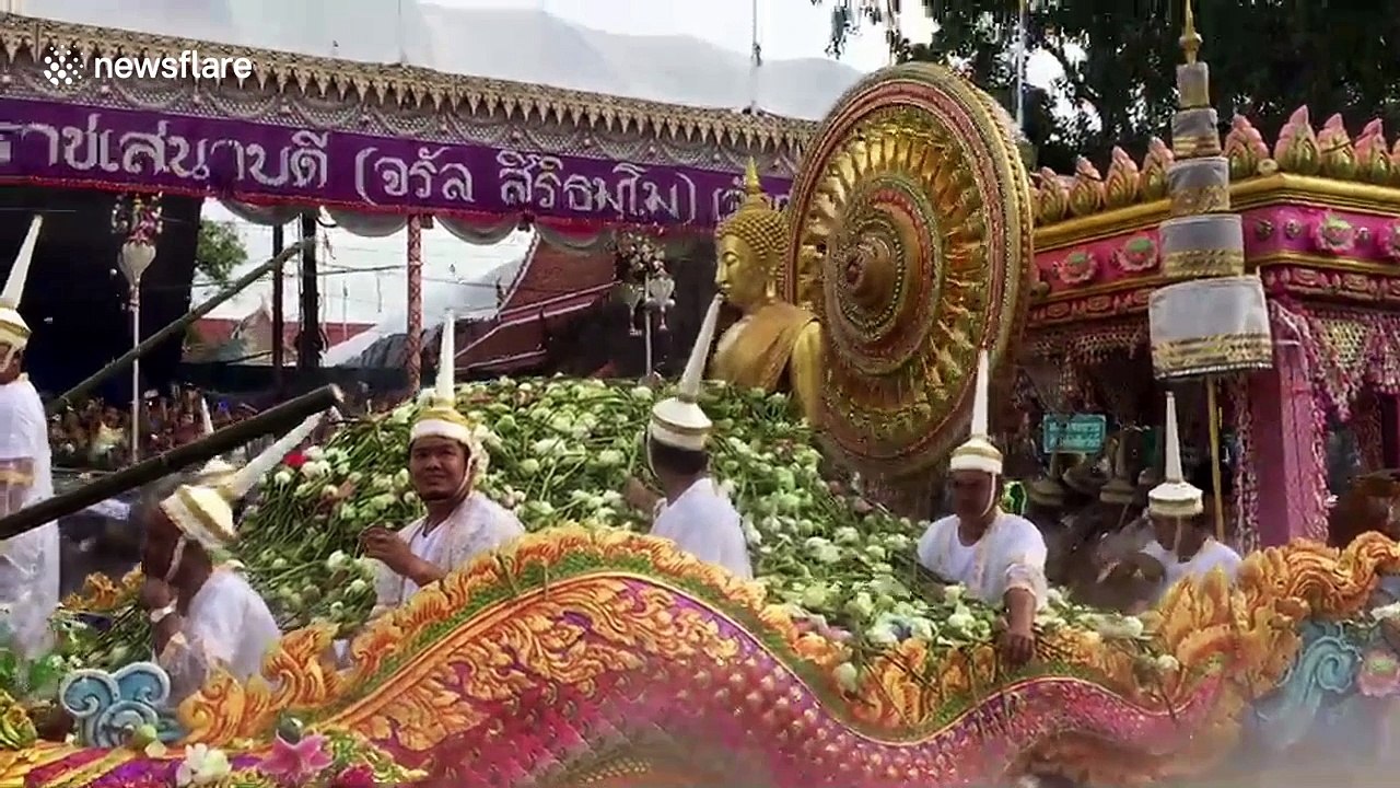 Thais mark the end of Buddhist Lent by throwing lotus flowers onto boats