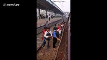 Commuters in Mumbai board packed rush-hour train from the wrong side