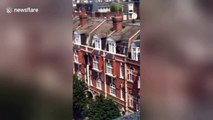 UK window cleaner seen on ledge three floors up with no safety equipment