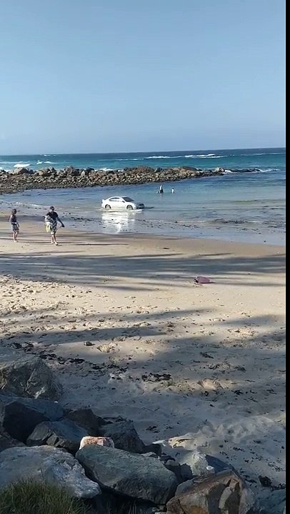 Il nettoie les roues de sa voiture dans la mer