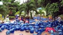 Hundreds of water dispensers float down flooded street after heavy downpour