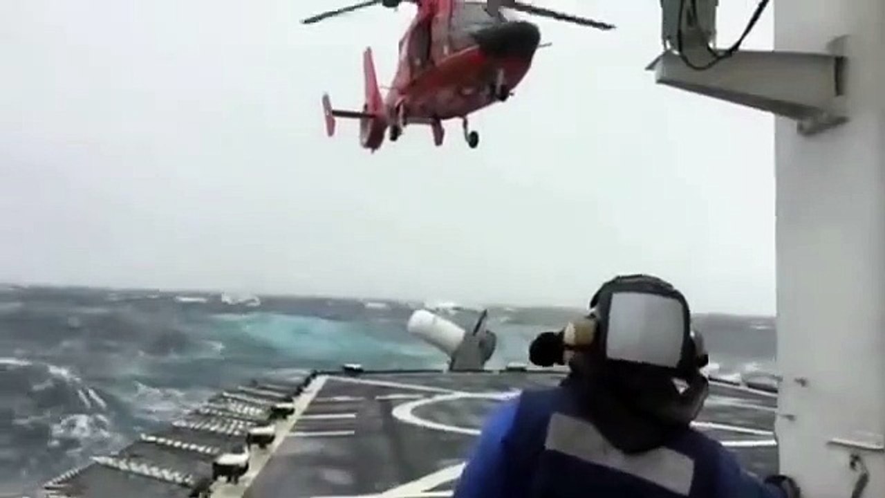 Un hélicoptère tente d'atterrir sur un bateau en pleine tempête