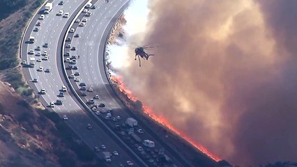 Cet hélicoptère largue des tonnes d'eau sur une autoroute au bord des flammes en Californie
