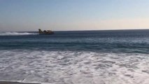 Des canadairs font le plein d'eau dans l'océan en bord de plage en Californie