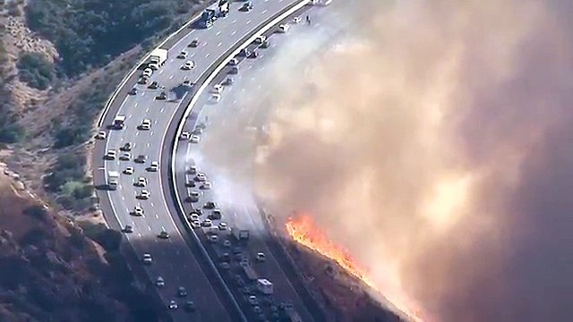 Les images d'un hélicoptère qui largue de l'eau sur une autoroute au bord des flammes (Californie)... Incroyable