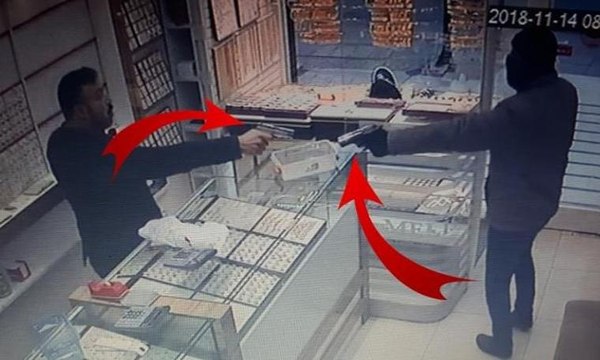 Silahlı soyguncuya tabancayla ateş ederek karşılık verdi