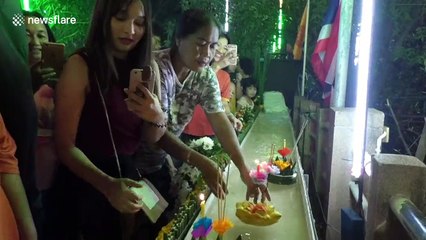 Worshippers send candle-lit baskets down a flume for Loy Krathong festival in Thailand