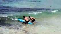 2 sauveteurs en mer sauvent un requin coincé dans un filet en bord de mer à Bondi Beach