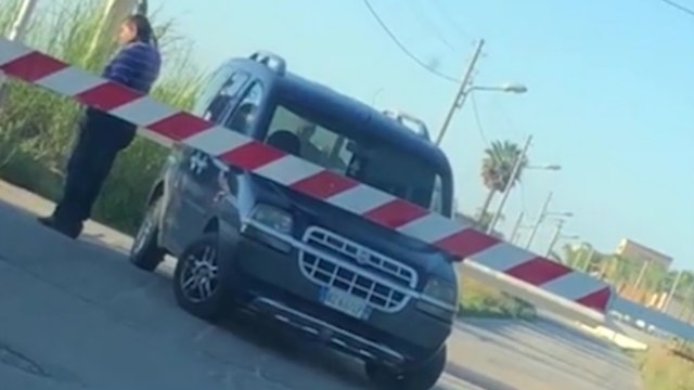 Un automobiliste bloqué à un passage à niveau fait coucou au train pour l'arrêter