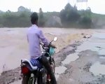 man riding bike swept away by flood floodwaters