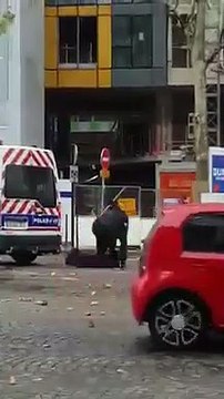 Paris : une manifestante filme des policiers en train de se déguiser en casseur derrière un fourgon de la police.