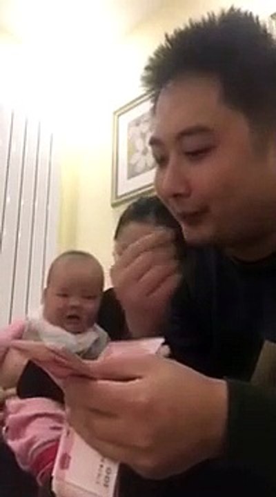 Chinese baby laughs hysterically while his father counts money