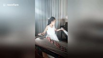 Talented Chinese girl plays piano and Chinese string instrument simultaneously